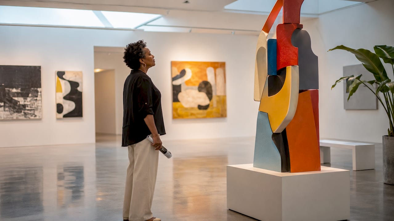 Woman viewing framed painting in gallery
