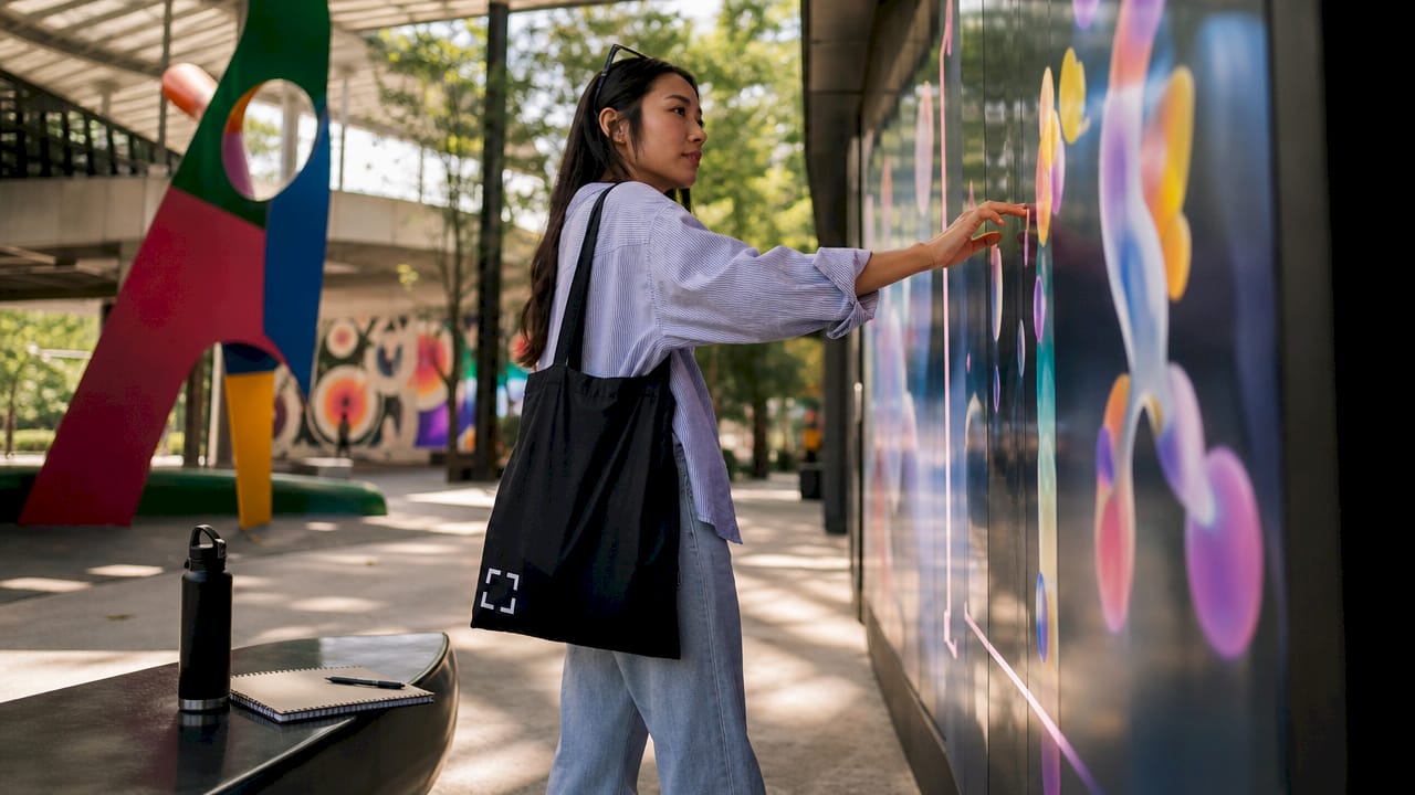 Woman interacting with digital art wall