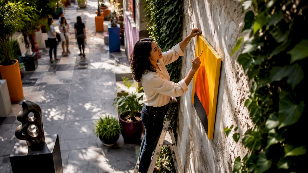 Curator installing custom-sized artwork in gallery
