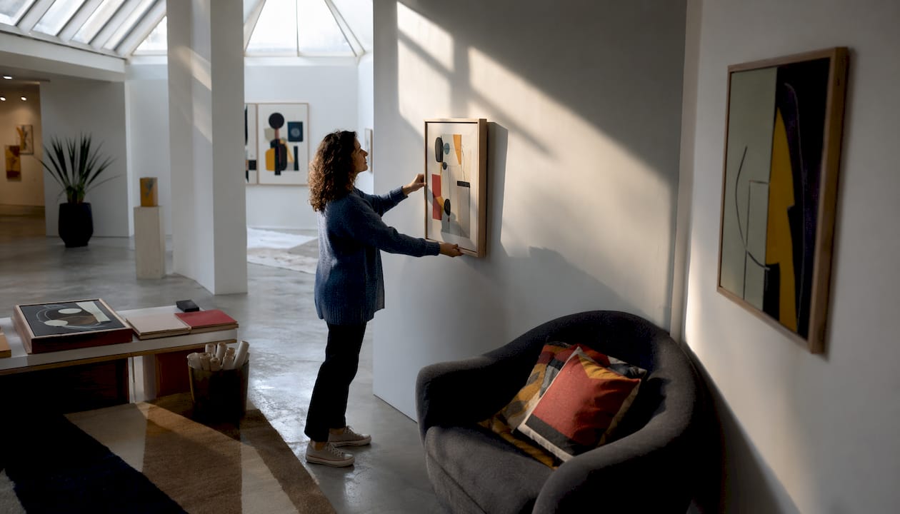 Woman contemplating hanging art in living room